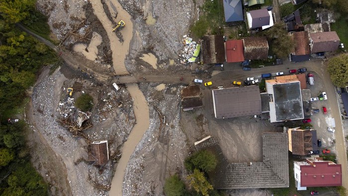 A destroyed car and a house are seen following a flooding in Buturovic Polje, Bosnia, Sunday, Oct. 6, 2024. (AP Photo/Armin Durgut)