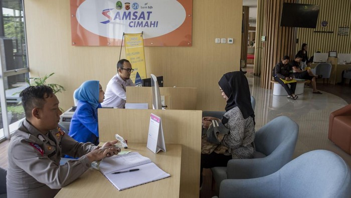 Petugas melayani warga yang membayar pajak kendaraan bermotor di bagian Samsat Cimahi Mal Pelayanan Publik (MPP), Cimahi, Jawa Barat, Senin (7/10/2024). Pemerintah Daerah Provinsi Jawa Barat mengadakan program pemutihan pajak kendaraan bermotor berupa bebas bea balik nama kepemilikan kendaraan bekas (BBNKB II), bebas denda pajak kendaraan bermotor, diskon pajak kendaraan bermotor,  bebas denda SWDKLLJ untuk tahun yang lewat serta bebas tunggakan pokok selama periode pembayaran 1 Oktober hingga 30 November 2024. ANTARA FOTO/Abdan Syakura/NA/nym.