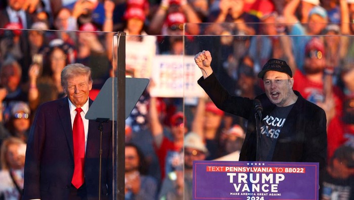 Tesla CEO and X owner Elon Musk speaks as Republican presidential nominee and former U.S. president Donald Trump looks on during a rally at the site of the July assassination attempt against Trump, in Butler, Pennsylvania, U.S., October 5, 2024. REUTERS/Carlos Barria     TPX IMAGES OF THE DAY