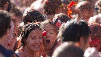 Setiap tahun, ribuan orang datang ke kota Bunol, Spanyol, untuk ikut serta dalam perang tomat terbesar di dunia. La Tomatina adalah festival di mana para peserta saling melempar tomat di jalanan, menciptakan pemandangan yang seru dan berantakan. AP Photo/Peter Dejong.