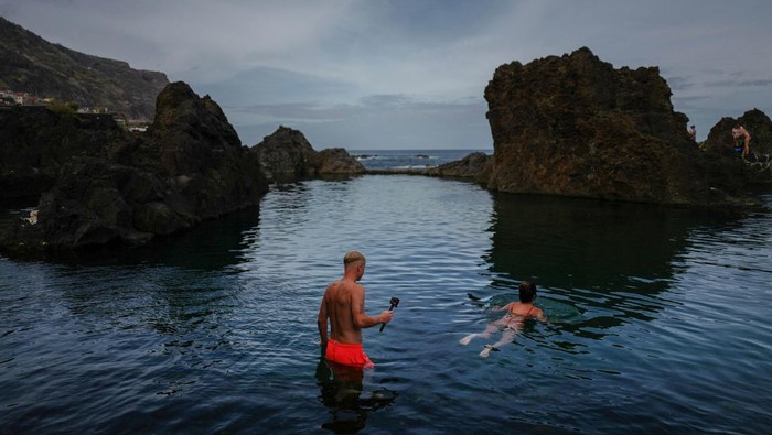 People enjoy a natural swimming pool in Porto Moniz on the Portuguese island of Madeira, Portugal, October 6, 2024. REUTERS/Pedro Nunes