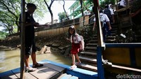 Tidak hanya SMP, ada juga siswa SD yang menaiki perahu eretan untuk menyeberangi Kali Pesanggrahan.