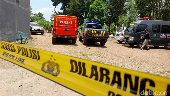 Polisi memasang garis dilarang saat melakukan ekshumasi makam warga Songgom, Brebes, Senin (7/10/2024).