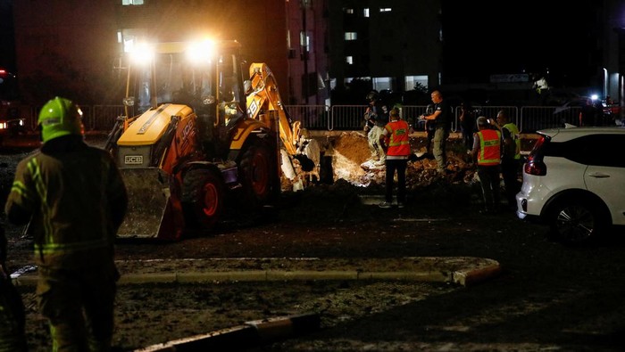 An Israeli rescue force member inspects the site where a projectile fell,amid cross-border hostilities between Hezbollah and Israel, in Haifa, northern Israel October 7, 2024. REUTERS/Shir Torem REFILE - CORRECTING DATE FROM 