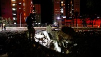 Seorang anggota pasukan penyelamat Israel memeriksa lokasi jatuhnya proyektil, di tengah permusuhan lintas batas antara Hizbullah dan Israel, di Haifa, Israel utara, Senin (7/10/2024). (REUTERS/Shir Torem)  