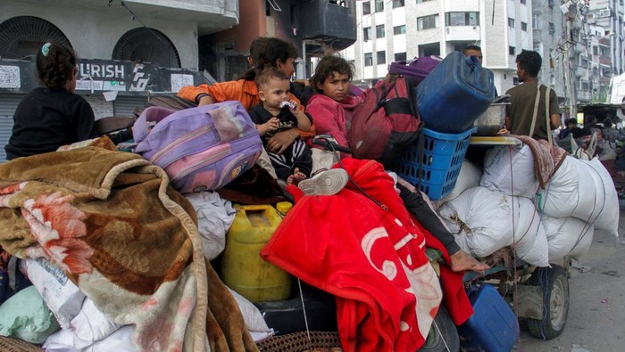 Setahun Genosida di Gaza, Warga Terus Berpindah untuk Mengungsi Displaced Palestinians make their way as they flee areas in northern Gaza Strip following an Israeli evacuation order, amid the Israel-Hamas conflict, in Jabalia, October 6, 2024. REUTERS/Hussam Al-Zaanin