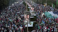 Orang-orang turun ke jalan, mengibarkan bendera Palestina, serta foto-foto korban perang. Mereka mengecam kejahatan Israel terhadap Gaza. (AP Photo/Fareed Khan)