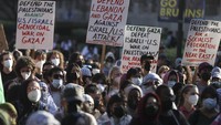 Para demonstran membawa spanduk di kampus UCLA pada peringatan satu tahun serangan Hamas terhadap Israel, di Los Angeles, Senin (7/10/2024). (AP Photo/Ethan Swope)  