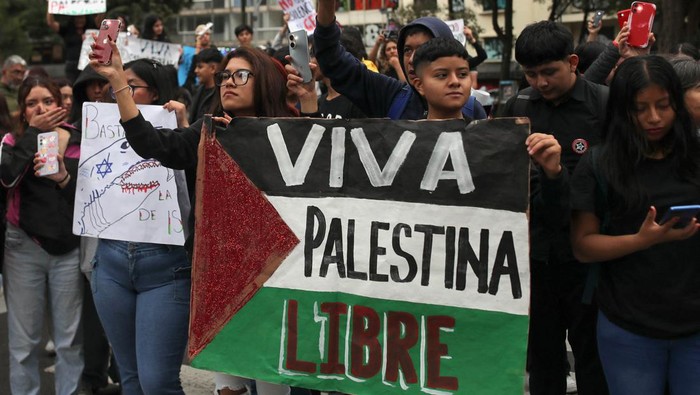 Aksi Warga Dunia Peringati 1 Tahun Perang Israel-Hamas di Gaza Demonstrators hold a sign that reads