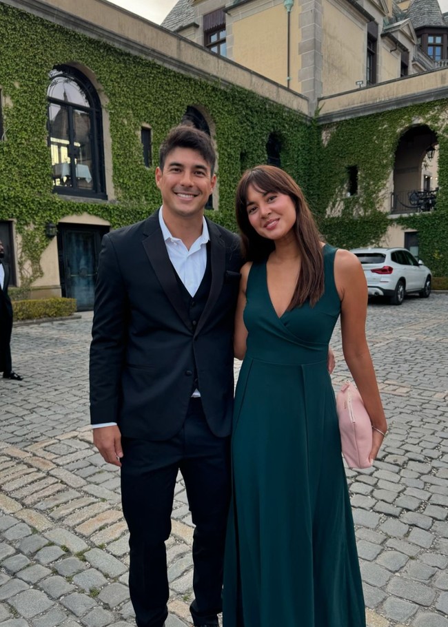 Aurelie tampil cantik mengenakan dress panjang tanpa lengan berwarna hijau. Sementara tunangannya, Tyler, mengenakan setelan jas hitam dan kemeja putih. Foto: Instagram/@drtylerbigenho