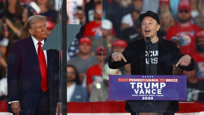 Tesla CEO and X owner Elon Musk speaks as Republican presidential nominee and former U.S. president Donald Trump looks on during a rally at the site of the July assassination attempt against Trump, in Butler, Pennsylvania, U.S., October 5, 2024. REUTERS/Carlos Barria     TPX IMAGES OF THE DAY