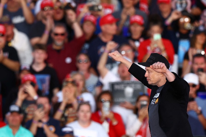 Tesla CEO and X owner Elon Musk speaks as Republican presidential nominee and former U.S. president Donald Trump looks on during a rally at the site of the July assassination attempt against Trump, in Butler, Pennsylvania, U.S., October 5, 2024. REUTERS/Carlos Barria     TPX IMAGES OF THE DAY