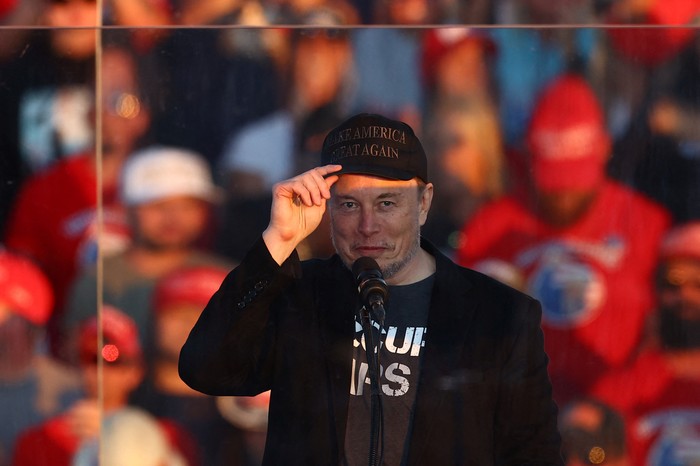 Tesla CEO and X owner Elon Musk speaks as Republican presidential nominee and former U.S. president Donald Trump looks on during a rally at the site of the July assassination attempt against Trump, in Butler, Pennsylvania, U.S., October 5, 2024. REUTERS/Carlos Barria     TPX IMAGES OF THE DAY