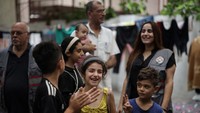 Sejumlah relawan membantu agar senyum anak-anak korban perang ini tidak hilang.