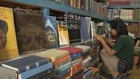 Penjual menulis harga buku-buku di Sentra Penjualan Barang Antik Jalan Surabaya, Menteng, Jakarta.  