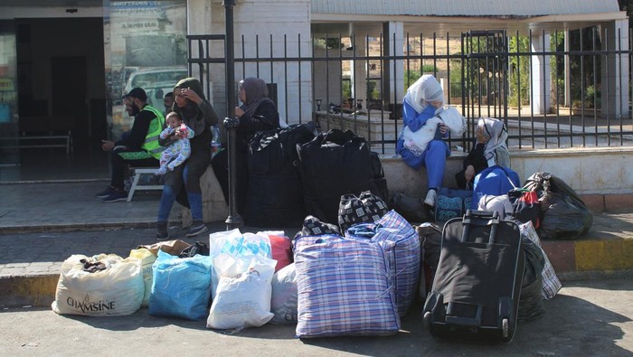 Warga Suriah Berbondong Balik ke Negaranya Imbas Perang di Lebanon Syrians, who were living in Lebanon and returned to Syria due to ongoing hostilities between Hezbollah and Israeli forces, wait outside Ministry of Interior Immigration and Passports Department, at the Syrian-Lebanese border in Jdaydet Yabous, Syria, October 7, 2024. REUTERS/Firas Makdesi