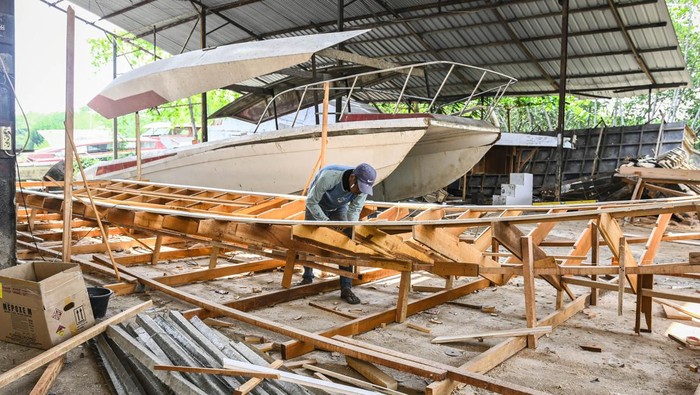 Pekerja menyelesaikan pembuatan kerangka cetakan kapal fiber di Galangan Kapal Arung Bahari Nusantara, Pulau Cangkir, Kabupaten Tangerang, Banten, Rabu (9/10/2024). Galangan kapal sejak 1997 tersebut menerima jasa pembuatan dan perbaikan kapal berbahan dasar fiber seperti kapal penumpang, kapal pancing hingga kapal ambulans yang dibanderol Rp100 juta hingga Rp6 miliar berdasarkan spesifikasi dan ukurannya. ANTARA FOTO/Sulthony Hasanuddin/aww.