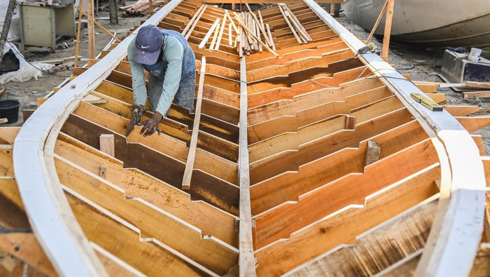 Pekerja menyelesaikan pembuatan kerangka cetakan kapal fiber di Galangan Kapal Arung Bahari Nusantara, Pulau Cangkir, Kabupaten Tangerang, Banten, Rabu (9/10/2024). Galangan kapal sejak 1997 tersebut menerima jasa pembuatan dan perbaikan kapal berbahan dasar fiber seperti kapal penumpang, kapal pancing hingga kapal ambulans yang dibanderol Rp100 juta hingga Rp6 miliar berdasarkan spesifikasi dan ukurannya. ANTARA FOTO/Sulthony Hasanuddin/aww.