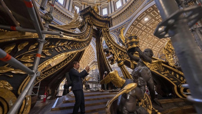 Scaffoldings envelope Bernini's monumental bronze canopy, Tuesday, Oct. 8, 2024, which is situated beneath Michelangelo's massive dome, whose twisting Solomonic columns' gleaming bronze has been concealed for nine months while expert conservators worked meticulously on its intricate surface. (AP Photo/Domenico Stinellis)