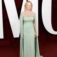 Meski makeup minimalis, Pamela Anderson tetap terlihat memesona dengan gaun hijau telur asin yang memiliki detail cape dengan panjang menyapu lantai. Bagian bahu dari gaun Pamela dibuat transparan dengan detail untaian mutiara perak. Foto: FilmMagic/Taylor Hill