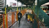Warga melintas di JPO yang sedang dipercantik.  