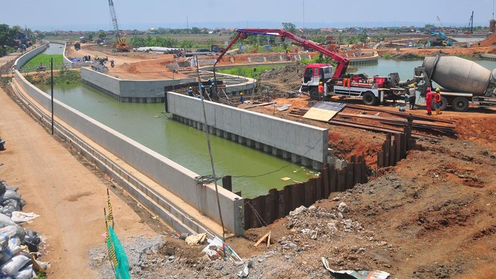 Pekerja menyelesaikan pembangunan kolam retensi di Desa Jati Wetan, Kudus, Jawa Tengah, Rabu (9/10/2024). Pembangunan kolam retensi atau waduk penampungan air hujan dalam jangka waktu tertentu seluas lima hektare oleh Kementerian PUPR dengan APBN sebesar Rp350 miliar itu pengerjaannya sudah mencapai 80 persen, dan ditargetkan selesai Desember 2024 dengan harapan dapat mengurangi banjir hingga 80 persen di wilayah itu. ANTARA FOTO/Yusuf Nugroho/foc.