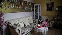 Memasuki pintu depan di lantai satu, langsung ada ruang tamu dengan sofa putih. Priscilla menghias ruangan ini dengan memasang wallpaper berwarna kuning dan memajang koleksi sendok-sendok souvenir dari mancanegara. Selain itu, ada rak-rak untuk untuk memajang souvenir lainnya. Foto: Pradita Utama