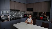 Ruang keluarga menyatu dengan dapur dan meja makan tanpa ada sekat. Interior dapur Priscilla tampak modern dan bernuansa gelap. Foto: Pradita Utama