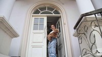 Ini pintu masuk rumah yang bernuansa putih itu. Rumah ini terdiri dari tiga lantai, yakni basement, lantai satu, dan lantai dua. Ada empat kamar tidur di rumah ini, tiga di antaranya di lantai dua dan satu kamar di lantai satu. Lalu, ada satu kamar mandi di setiap lantai. Foto: Pradita Utama