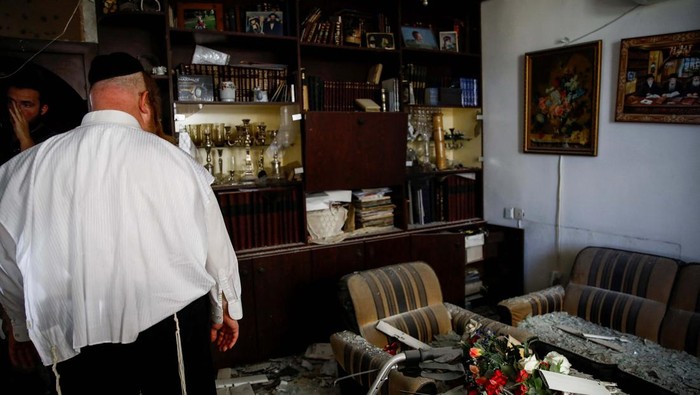 People stand inside a residential apartment building that was damaged by a rocket fired from Lebanon, amid hostilities between Hezbollah and Israel, in Kiryat Yam, northern Israel, October 8, 2024. REUTERS/Shir Torem     TPX IMAGES OF THE DAY