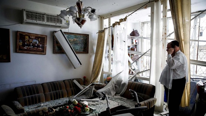 Rumah-rumah di Kiryat Yam Israel Rusak Dirudal Hizbullah People stand inside a residential apartment building that was damaged by a rocket fired from Lebanon, amid hostilities between Hezbollah and Israel, in Kiryat Yam, northern Israel, October 8, 2024. REUTERS/Shir Torem TPX IMAGES OF THE DAY
