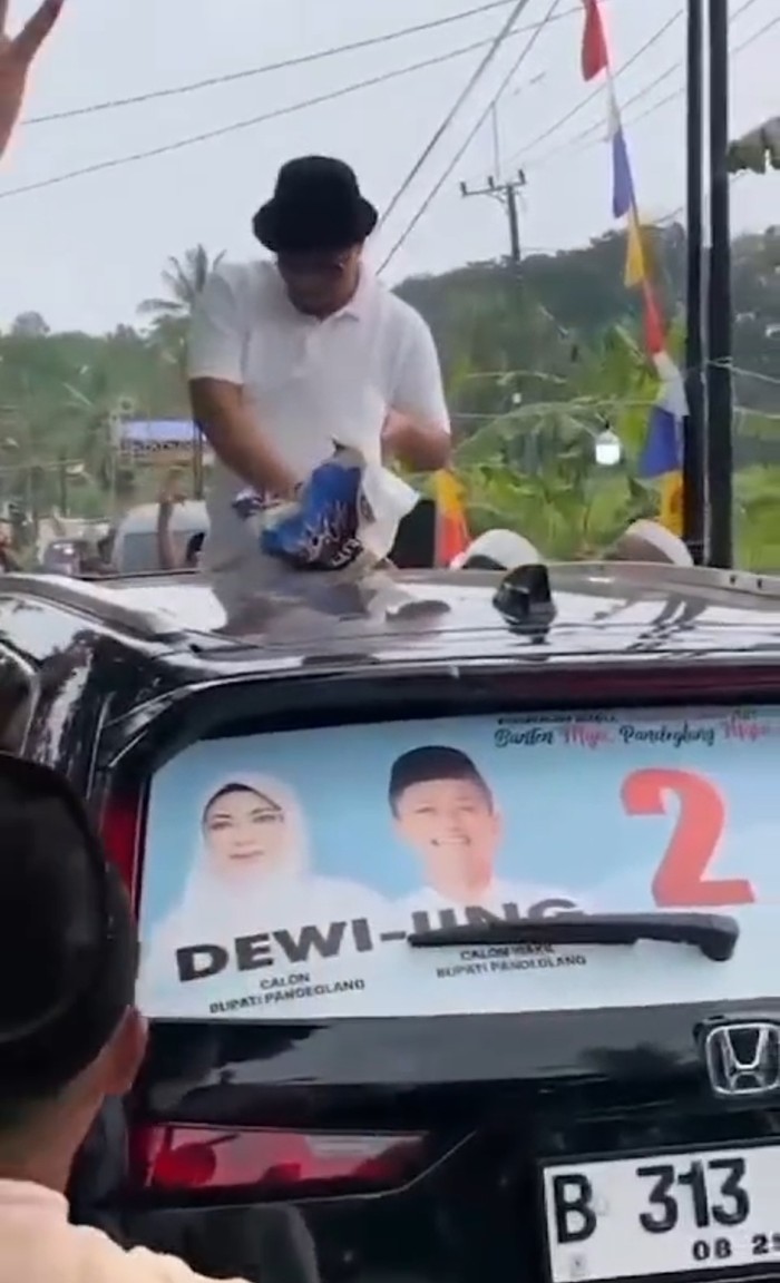 Viral beredar, video yang memperlihatkan seorang pria membagikan duit dari atas mobilnya di Pandeglang. (Dok Istimewa)