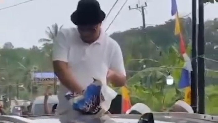 Viral beredar, video yang memperlihatkan seorang pria membagikan duit dari atas mobilnya di Pandeglang. (Dok Istimewa)