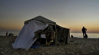 Salah seorang pengungsi Zeina Nazha dan putrinya yang masih kecil berkemah di pantai kota, mencari keamanan dari perang di Lebanon.