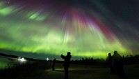Aurora terjadi ketika partikel bermuatan dari matahari bertabrakan dengan molekul oksigen dan nitrogen di atmosfer atas Bumi. (Courtesy of All About Lapland/Alexander Kuznetsov via REUTERS)