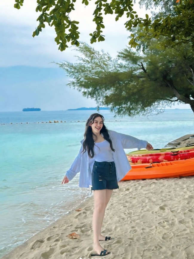 Selama berlibur di pulau Ayu tampil simpel. Rambut panjangnya pun seringkali hanya dibiarkan terurai dan diikat setengah. Seperti dalam foto, Ayu tampak memadukan tanktop putuh dengan kemeja dan celana jeans pendek. Foto: Instagram/@ayutingting92