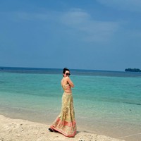 Ayu juga tampil seksi kala mengenakan set rok berupa atasan crop top tali spaghetti dan rok panjang bermotif warna merah dan hijau. Penampilannya kemudian dilengkapi dengan kaca mata hitam. Foto: Instagram/@ayutingting92