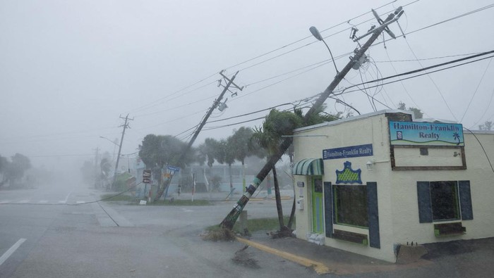 Parts of the roof of a gas station lie around palm trees after a passing tornado affected the area as Hurricane Milton approaches Fort Myers, Florida, U.S. October 9, 2024. REUTERS/Ricardo Arduengo