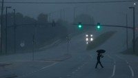 Seorang pria berjalan di jalan saat Badai Milton mendekat, di Orlando, Florida, AS. Petir sempat memutus aliran listrik ke lampu lalu lintas saat Badai Milton bergerak melintasi Florida tengah pada hari Kamis (10/10/2024). REUTERS/Jose Luis Gonzalez