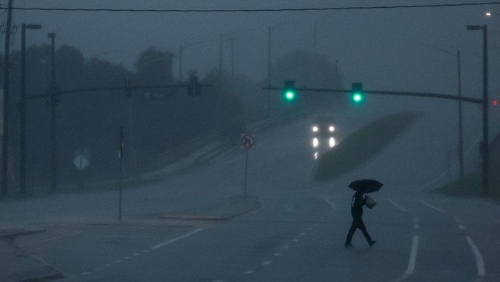 Gelap Gulita Florida Saat Badai Milton Menerjang A man walks down an avenue as Hurricane Milton approaches, in Orlando, Florida, U.S., October 9, 2024. REUTERS/Jose Luis Gonzalez TPX IMAGES OF THE DAY