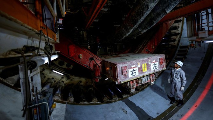 A member of staff works on the construction of the Ring Road No. 7 Underground Regulating Reservoir, near Nogata station in Tokyo, Japan, July 16, 2024. The system kicked in four times in June, more than all of last year, capturing water before pumping it safely into the Edogawa River and out to sea. 