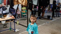 Anak-anak berpose di sekolah yang diubah menjadi tempat penampungan sementara bagi para pengungsi, selama kunjungan anggota parlemen Hizbullah, di tengah permusuhan yang sedang berlangsung antara Hizbullah dan Israel, di Beirut, Lebanon, Rabu (9/10/2024).  