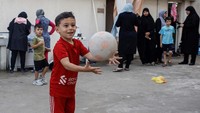 Seorang anak tengah bermain bola di lokasi pengungsian.  