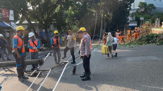 Proses evakuasi tiang listrik dan pohon petai tumbang di depan sebuah komplek di wilayah Srengseng, Jakarta Barat.