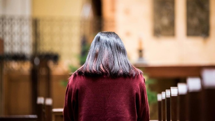 Orang sedang berdoa di gereja