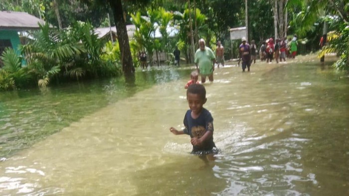 Sejumlah warga hingga anak-anak melintas banjir yang merendam Kampung Elles, Distrik Sawiat, Sorong Selatan.