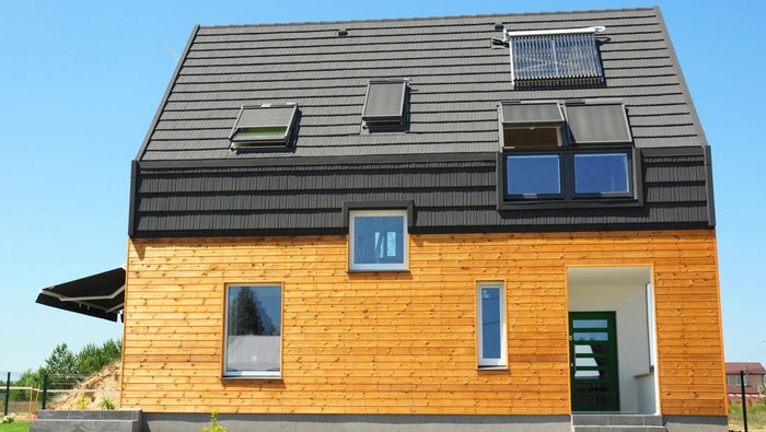 KIEV, UKRAINE - July, 09, 2014: Modern house with energy saving and energy efficiency. Eco-house or  wooden eco-home with attic skylights, insulation, solar panels and solar water heater (SWH) system. Passive House Concept.