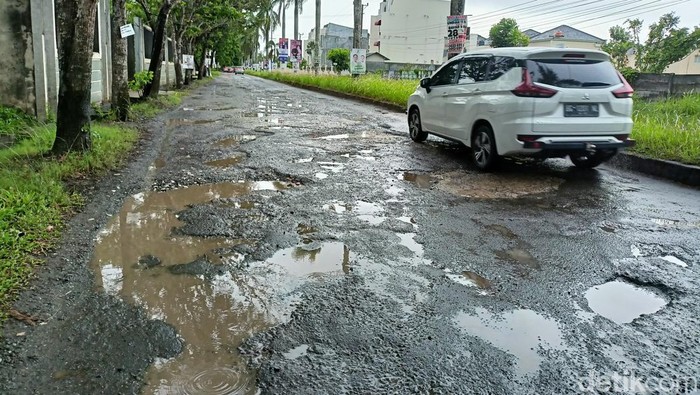 Jalan Opi Raya Palembang rusak dan berlubang.