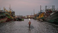 Pekerja berjalan di antara kapal yang bersandar di Pelabuhan Nizam Zachman, Muara Baru, Jakarta, Kamis (10/10/2024). ANTARA FOTO/Fauzan