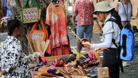 Seorang wisatawan mancanegara melihat-lihat kerajinan yang terbuat dari kulit kayu yang dipamerkan di Kampung Asei Besar, Distrik Sentani Timur, Kabupaten Jayapura, Papua, Kamis (10/10/2024).